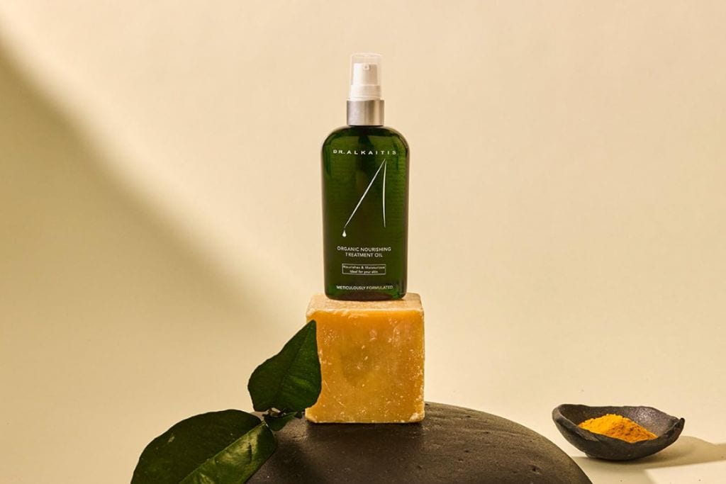 A green bottle sits on top of a yellow bar of soap.
